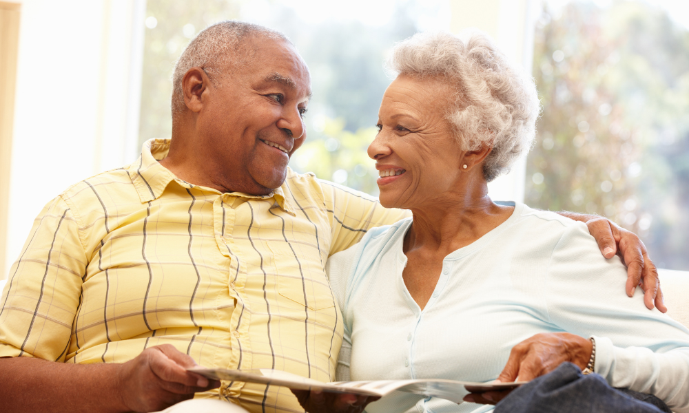 older black couple sitting on couch smiling