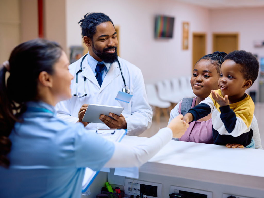 Female patient with child at counter with nurse and doctor