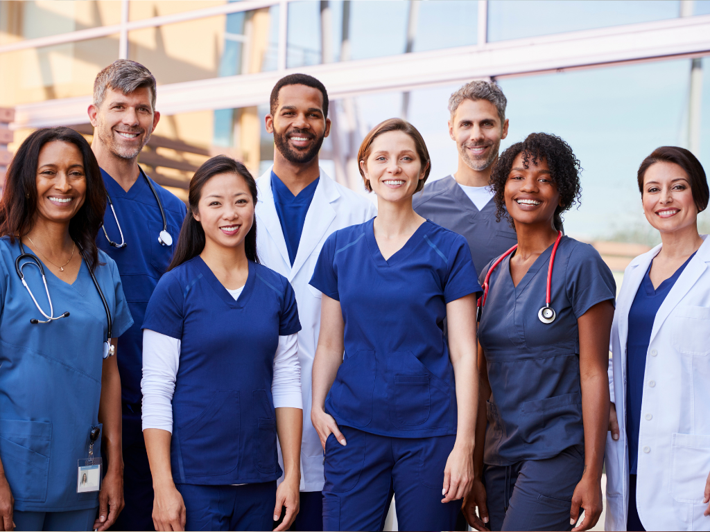 diverse group of clinicians and nurses smiling 